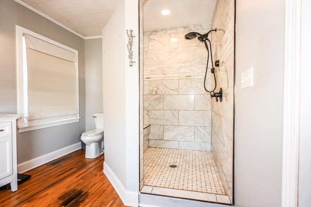 bathroom featuring visible vents, toilet, a shower stall, wood finished floors, and baseboards