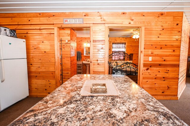 dining space featuring carpet and wooden walls