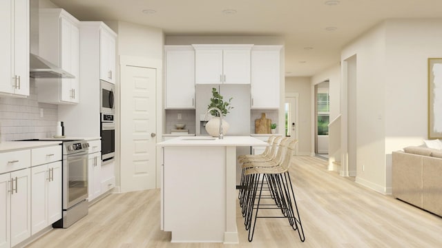 kitchen featuring a kitchen island with sink, a sink, white cabinetry, light wood-style floors, and appliances with stainless steel finishes