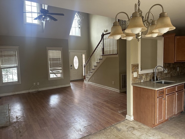 kitchen with visible vents, light countertops, light wood-style floors, a sink, and ceiling fan with notable chandelier