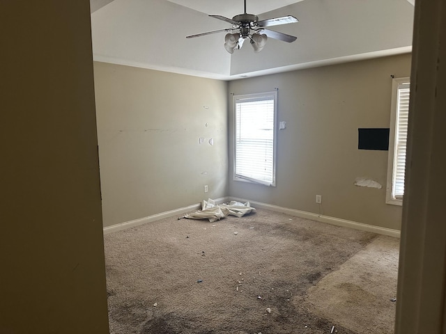 carpeted spare room with a ceiling fan and baseboards