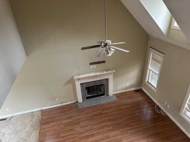 unfurnished living room featuring high vaulted ceiling, visible vents, a fireplace, and wood finished floors