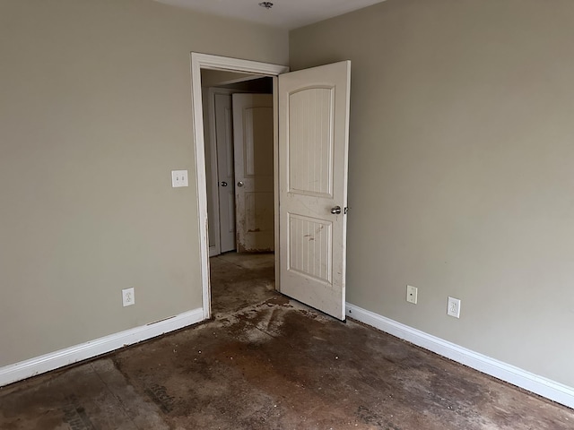 unfurnished bedroom featuring baseboards and unfinished concrete floors