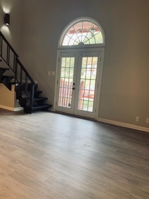 entryway with baseboards, stairway, wood finished floors, and french doors