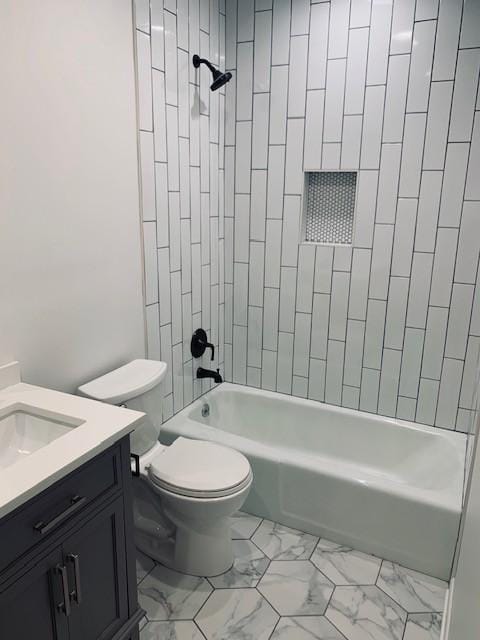 full bath featuring toilet, marble finish floor, bathtub / shower combination, and vanity