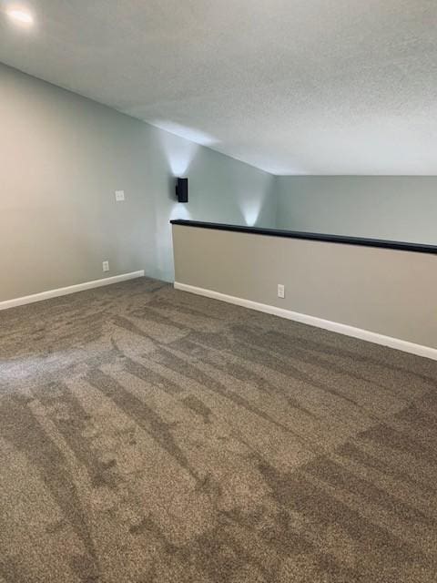 carpeted empty room with baseboards and a textured ceiling