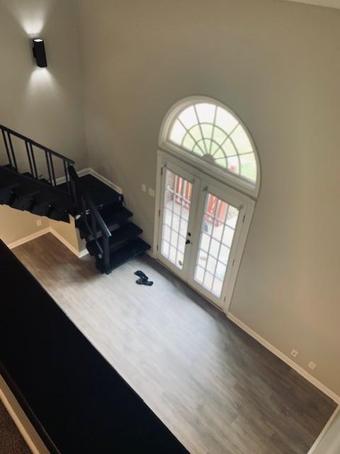 interior space featuring baseboards, stairway, and wood finished floors