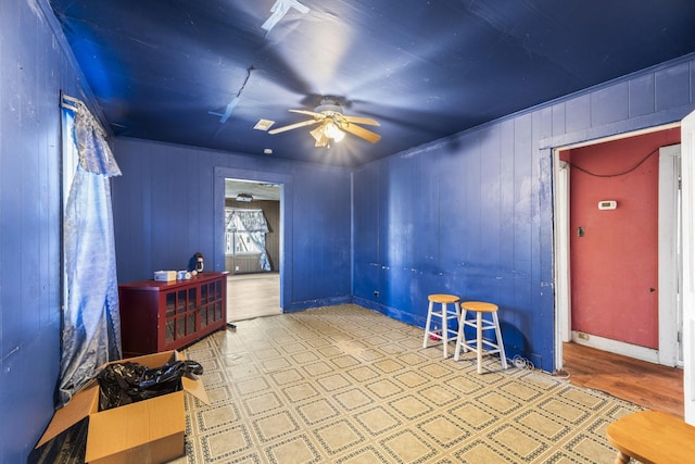 interior space with baseboards, a ceiling fan, and tile patterned floors