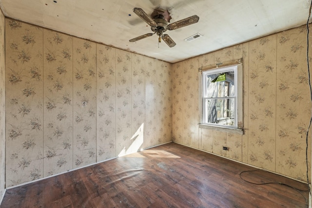 unfurnished room with ceiling fan, visible vents, and wood finished floors