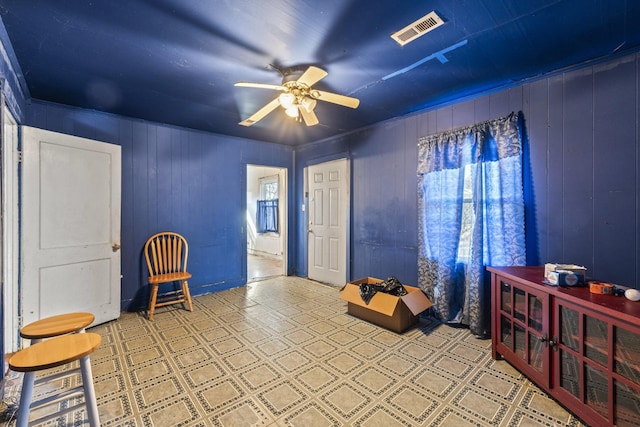 living area featuring a ceiling fan, visible vents, and light floors