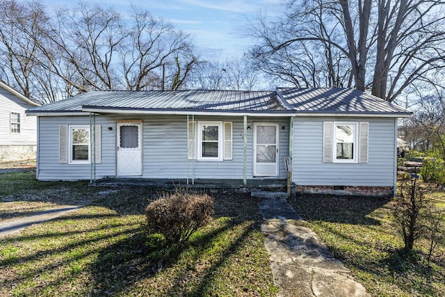 view of front of house featuring metal roof, a porch, crawl space, and a front yard