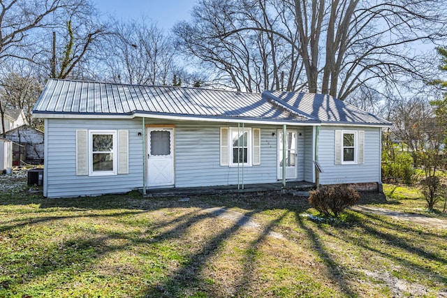 ranch-style house with covered porch, metal roof, and a front yard