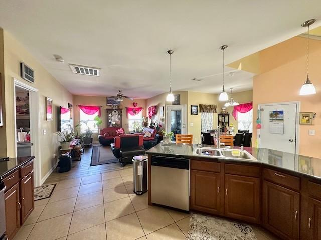 kitchen with light tile patterned floors, visible vents, open floor plan, a sink, and dishwasher