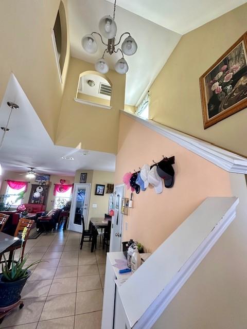 interior space with light tile patterned floors, high vaulted ceiling, and a chandelier