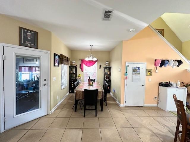 dining area with a healthy amount of sunlight, light tile patterned floors, visible vents, and a notable chandelier