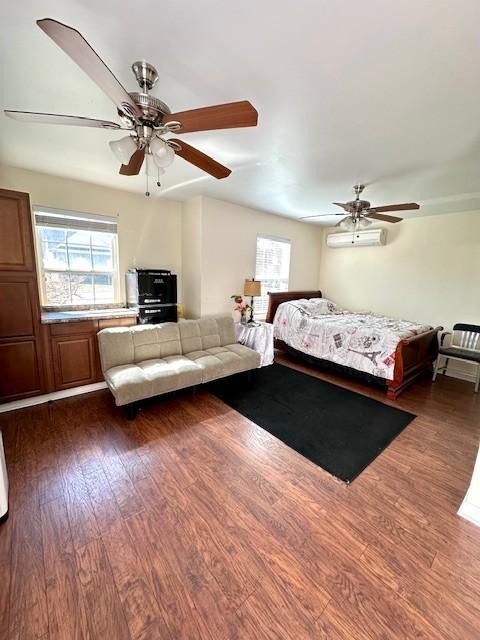 bedroom featuring ceiling fan, a wall mounted AC, and dark wood finished floors