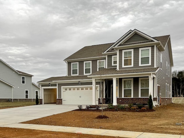 view of front of house with driveway, a porch, and brick siding