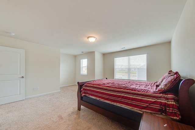 bedroom with light carpet and baseboards