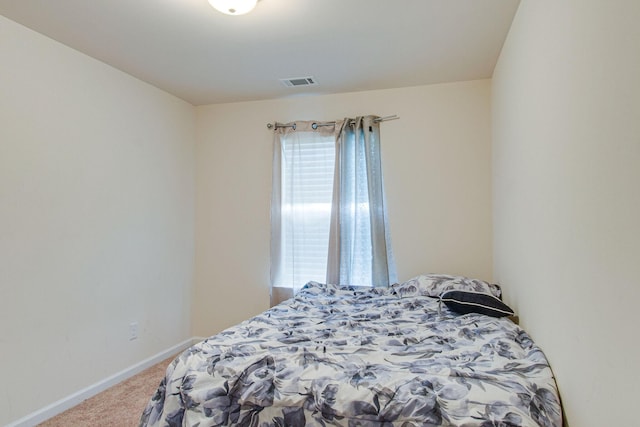 carpeted bedroom with visible vents and baseboards