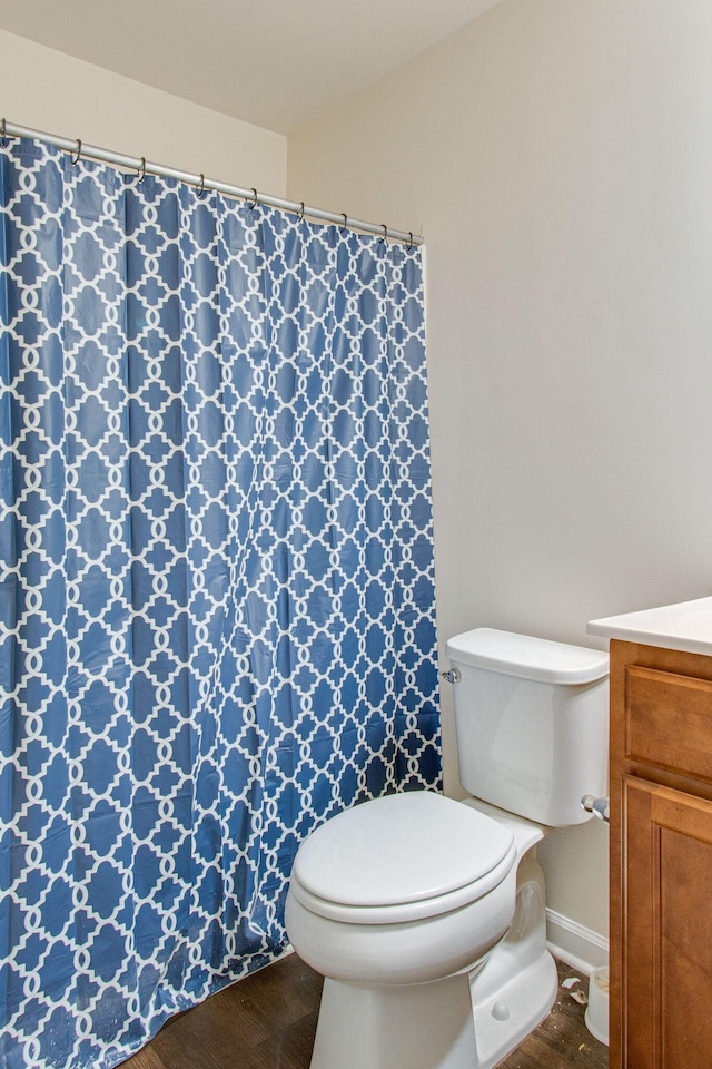 full bath featuring toilet, curtained shower, wood finished floors, and vanity