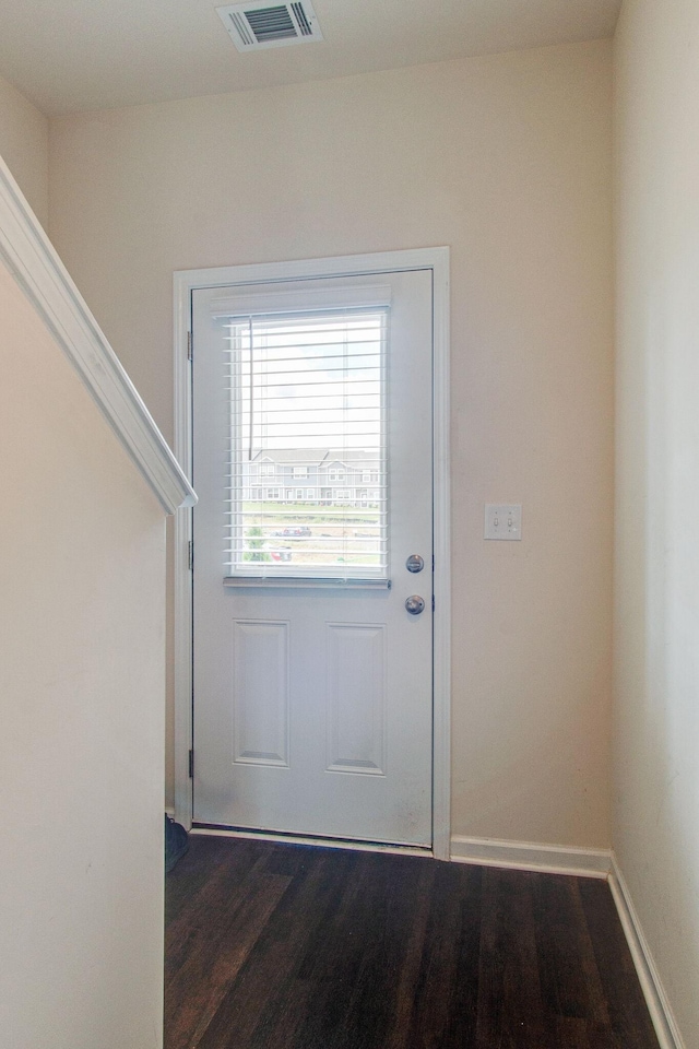 doorway featuring wood finished floors, visible vents, and baseboards