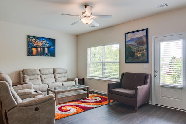 living room featuring a ceiling fan, visible vents, dark wood finished floors, and baseboards