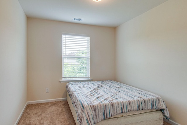 bedroom featuring carpet floors, visible vents, and baseboards