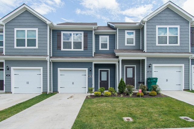 multi unit property featuring a garage, driveway, and a front yard