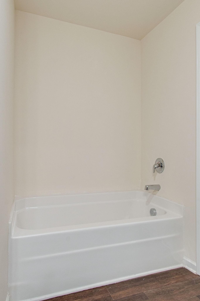 full bathroom featuring a washtub and wood finished floors