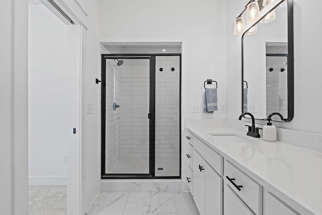 bathroom featuring marble finish floor, vanity, baseboards, and a stall shower