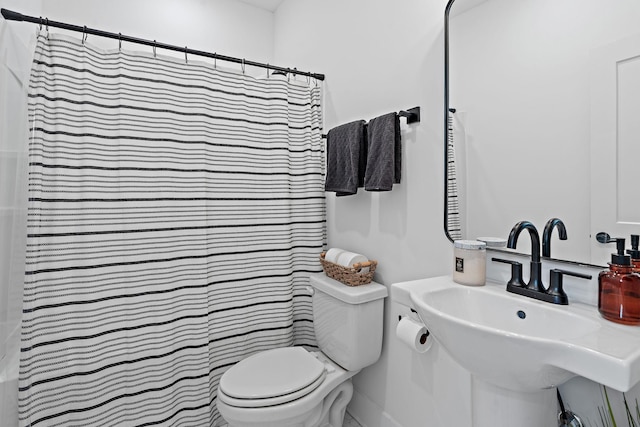 full bath featuring a sink, toilet, and a shower with curtain