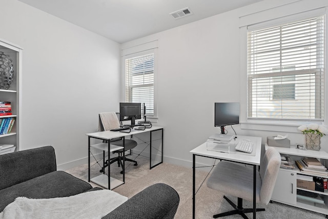 office space with carpet, visible vents, and plenty of natural light