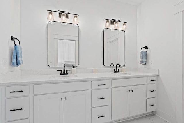 bathroom featuring double vanity, marble finish floor, baseboards, and a sink