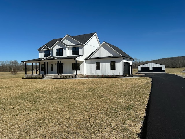 modern farmhouse style home featuring a porch and a front yard