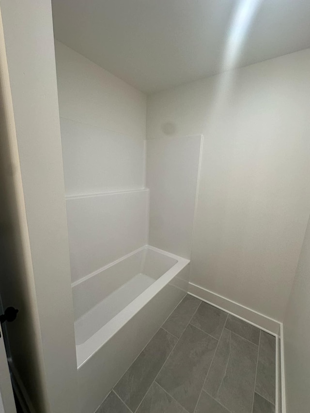 bathroom featuring bathing tub / shower combination and baseboards