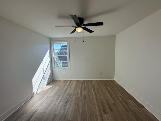 spare room with a ceiling fan, baseboards, and wood finished floors