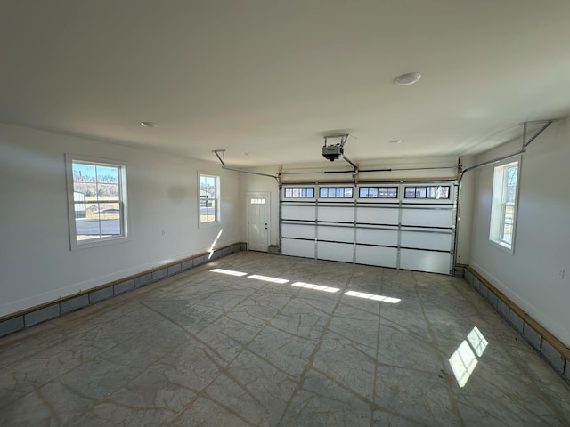 garage featuring baseboards, a baseboard radiator, and a garage door opener