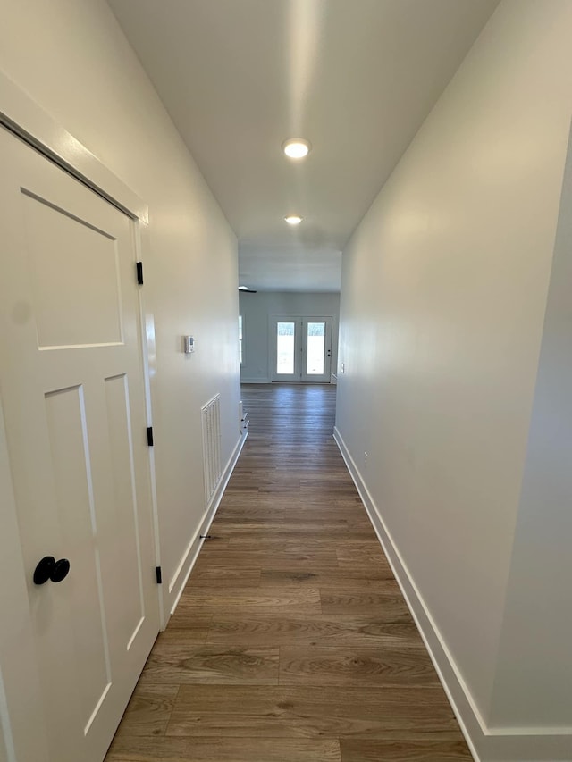 hall featuring dark wood-style floors, recessed lighting, visible vents, and baseboards