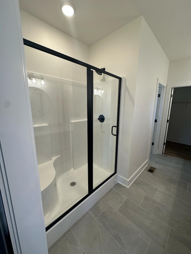 full bathroom featuring a stall shower, baseboards, visible vents, and tile patterned flooring