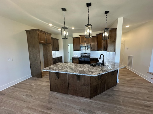 kitchen with dark stone countertops, visible vents, stainless steel appliances, and a sink