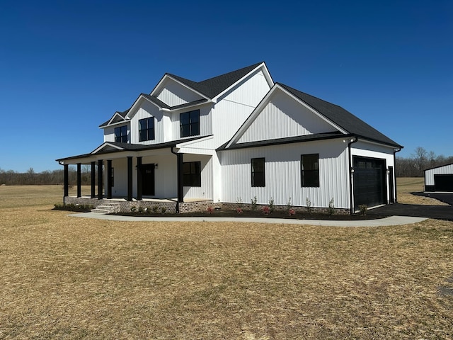 modern farmhouse featuring a garage and a porch