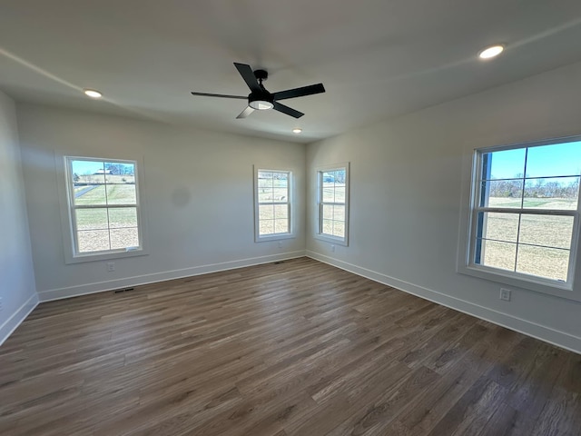 empty room featuring recessed lighting, dark wood-style flooring, visible vents, a ceiling fan, and baseboards