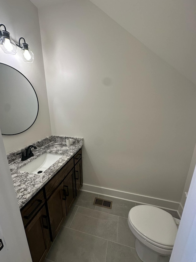 bathroom with visible vents, toilet, vanity, tile patterned flooring, and baseboards