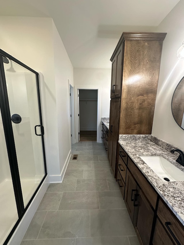 full bathroom with a stall shower, visible vents, vanity, and a spacious closet