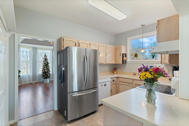 kitchen featuring light countertops, freestanding refrigerator, light brown cabinets, and dishwasher