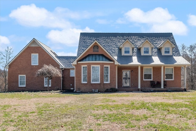 view of front facade featuring covered porch, brick siding, and a front lawn