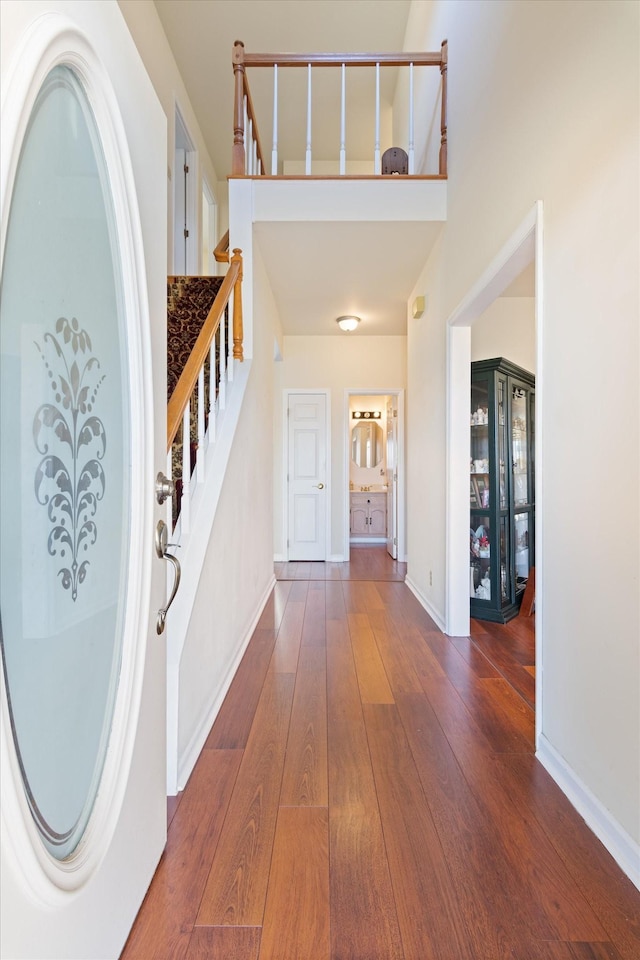 entryway with stairs, hardwood / wood-style floors, and baseboards