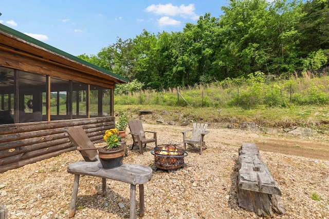 view of yard featuring an outdoor fire pit and a sunroom