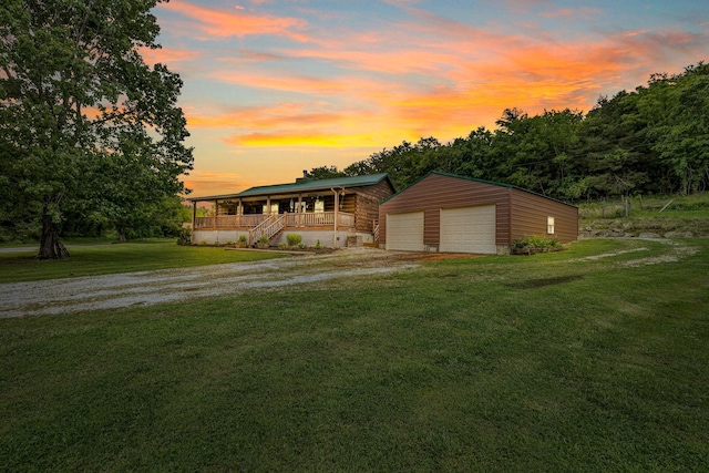 view of front of home with an outbuilding, a garage, driveway, and a front lawn