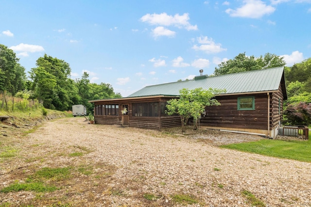 view of front of property featuring a sunroom and metal roof